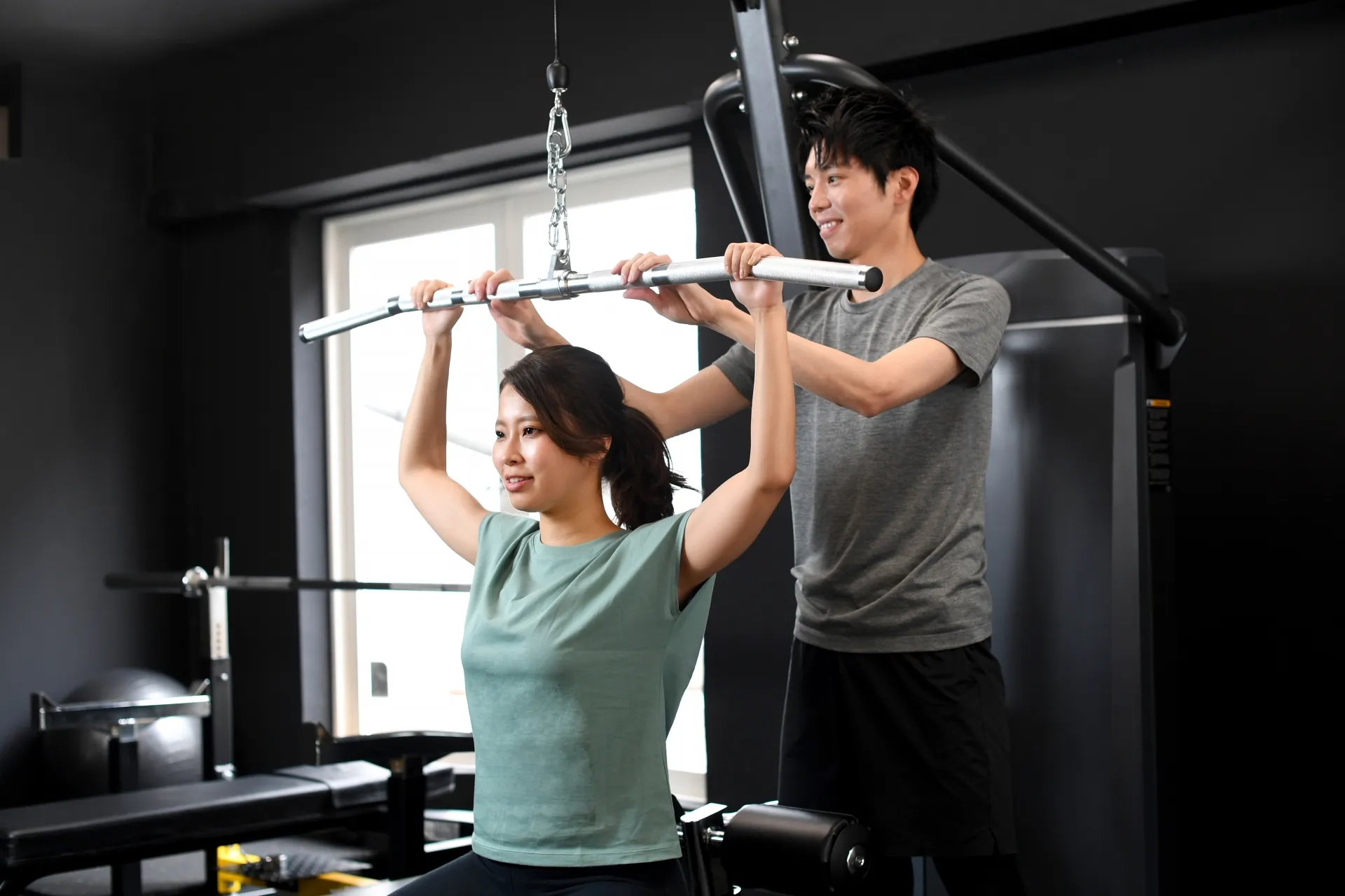 トレーナーがジムでフォームを確認している様子